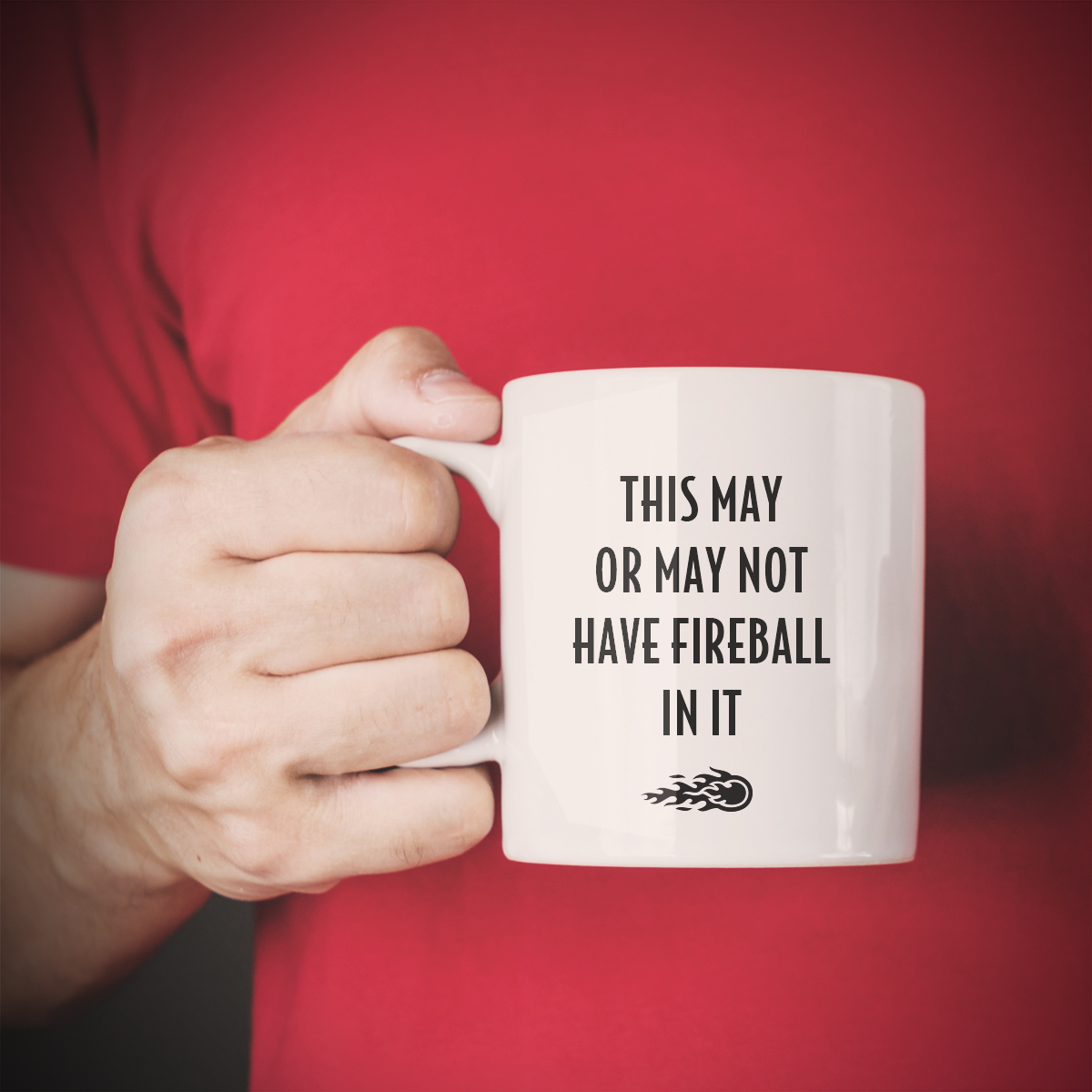 Man holding a mug that says "This may or May Not Have Fireball In It"