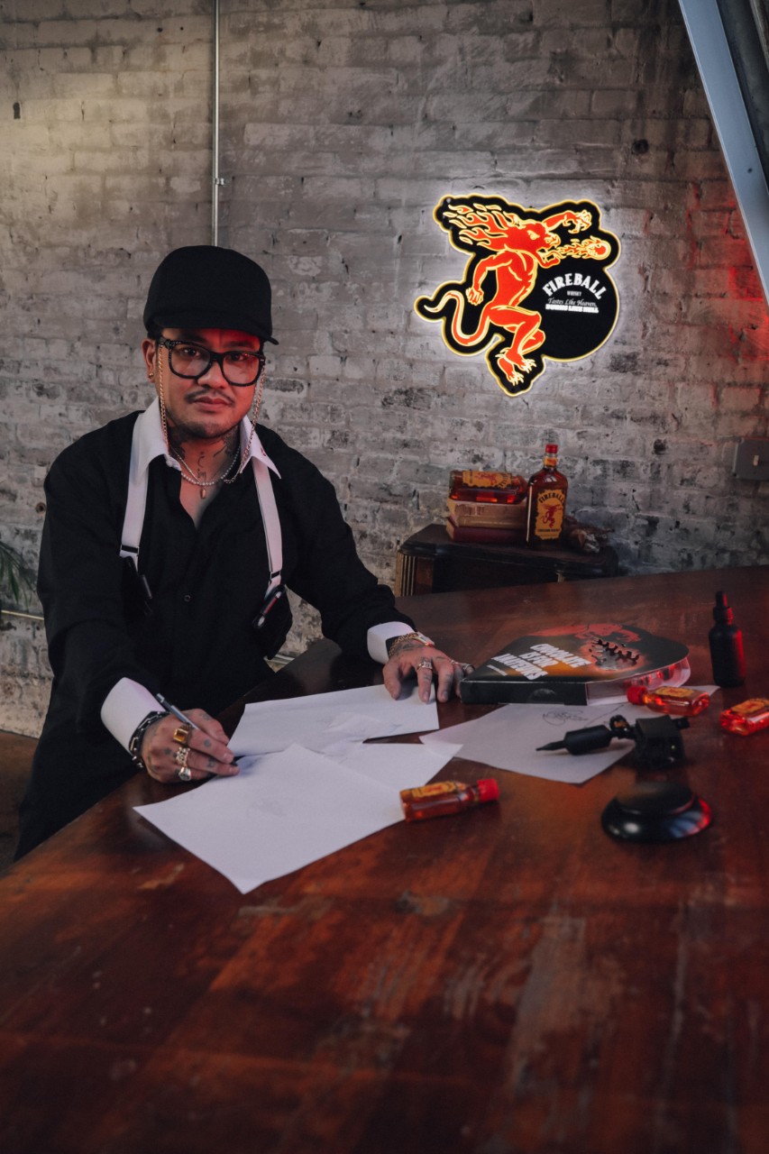 JonBoy at drafting table sketching Fireball tattoos