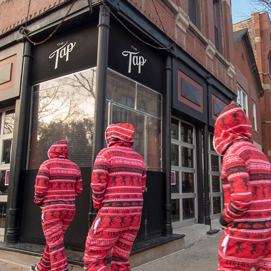 Three men wearing the Fireball Fugly Onsie walking to a bar