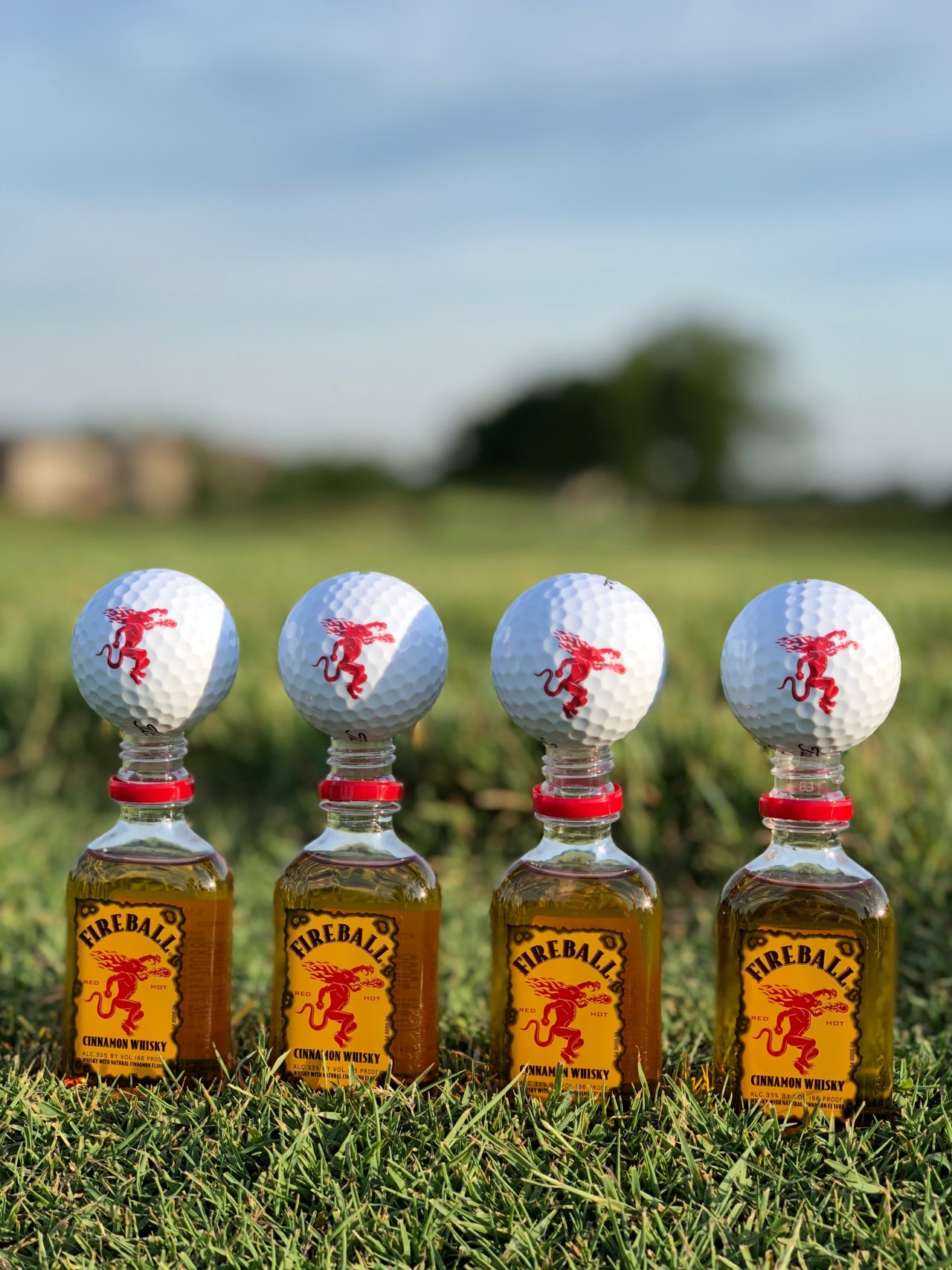 Fireball Golf Balls on top of 50ml bottles